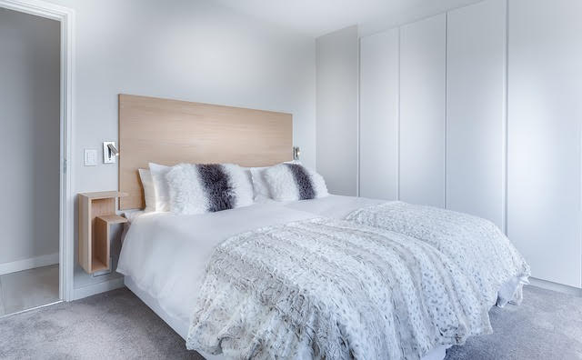 white room with wooden headboard