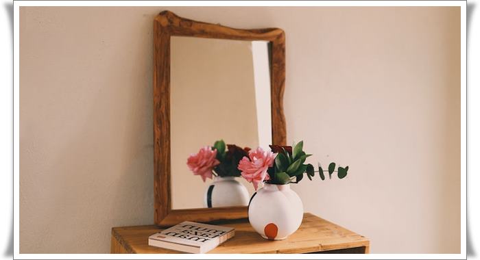 Wooden framed mirror supported by a base unit