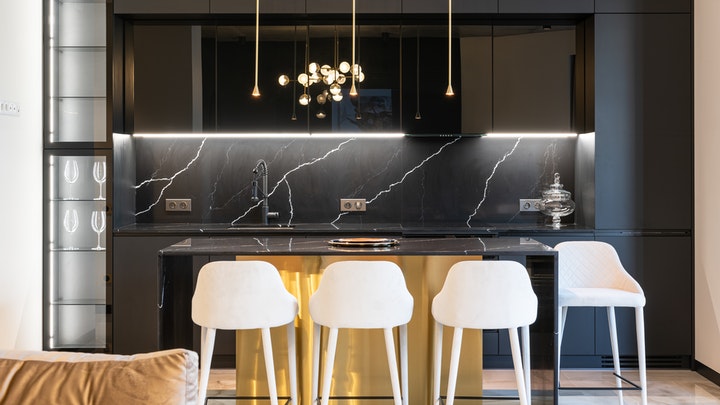 black kitchen island with white stools