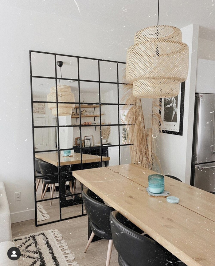 A dining room with a large mirror leaning against the wall