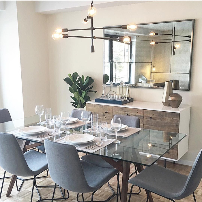 A dining room with a large mirror over the buffet