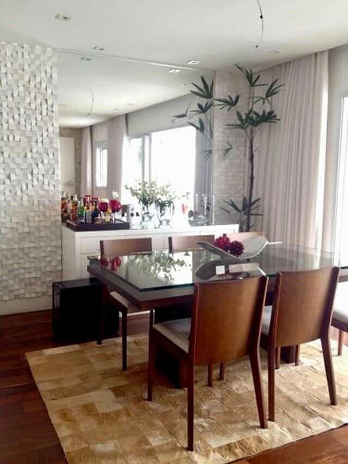 Dining room with a wall decorated with a large mirror and 3D coating