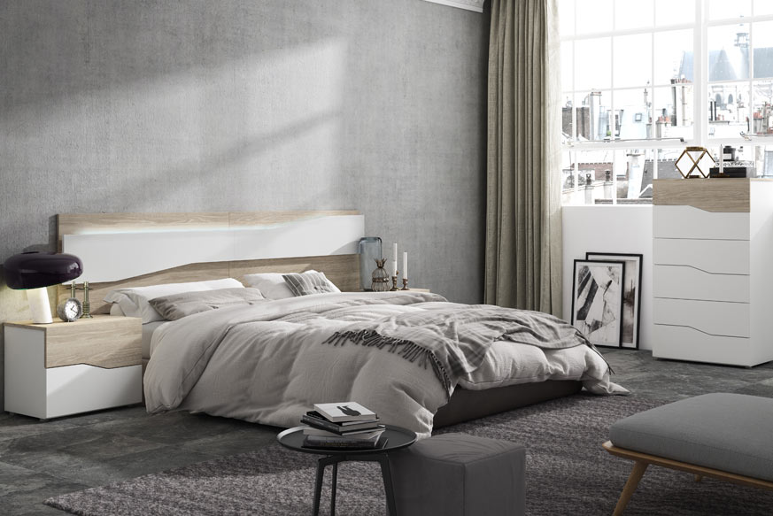 Oak and white bedroom with headboard, dresser and two nightstands.