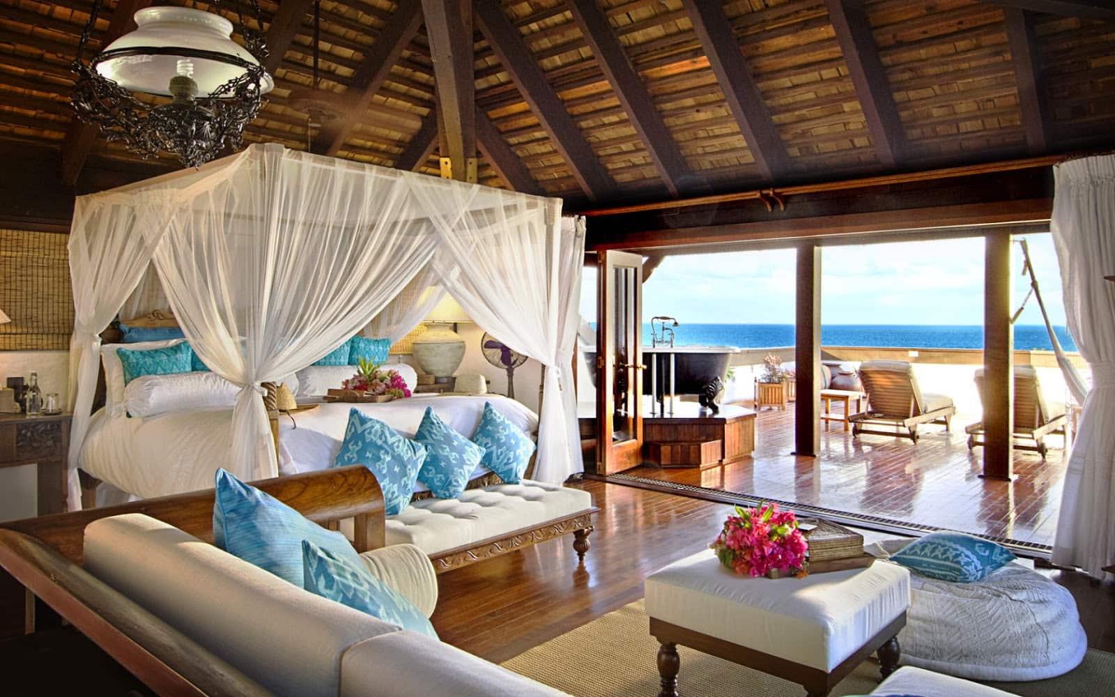 Beautiful outdoor design of oceanfront bungalow with white canopy bed in the middle