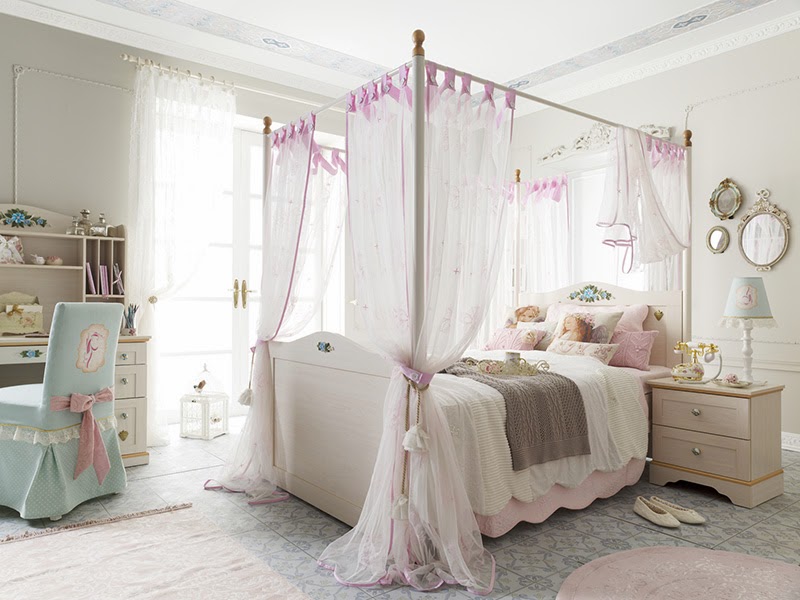 Elegant and soft bedroom arrangement with pink hanging high queen bed and tulle bed canopy