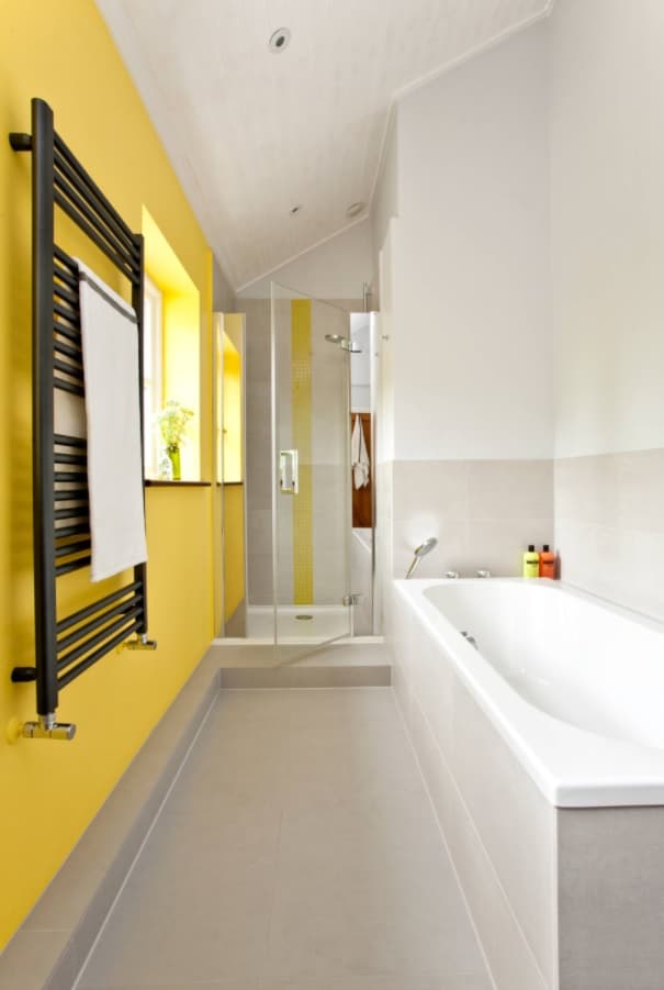 Making the Most of a Small Bathroom. A nice modern design in a compact space with an accent yellow wall and black wall heater